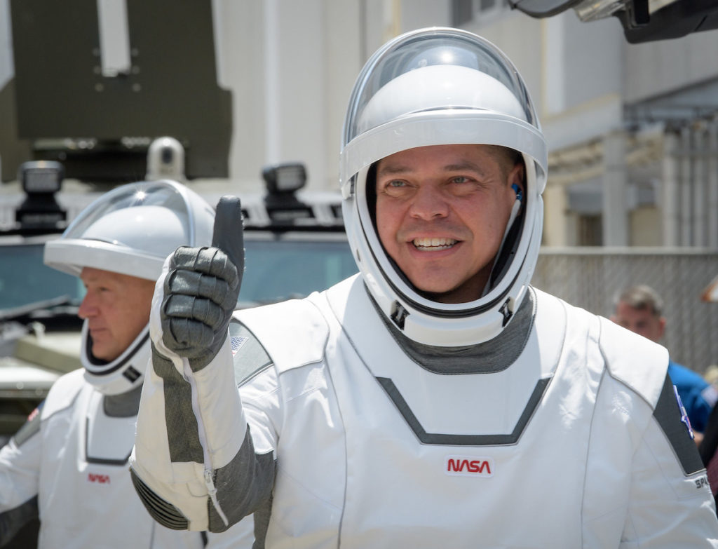 NASA astronauts Robert Behnken, foreground, and Douglas Hurley, wearing SpaceX spacesuits, are seen as they depart the Neil A. Armstrong Operations and Checkout Building for Launch Complex 39A to board the SpaceX Crew Dragon spacecraft for the Demo-2 mission launch. Image credit: NASA/Bill Ingalls