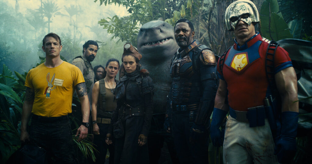 L-R: Joel Kinnaman as Colonel Rick Flag, Alice Braga as Sol Soria, Daniela Melchior as Ratcatcher 2, King Shark (voiced by Sylvester Stallone), Idris Elba as Bloodsport, and John Cena as Peacemaker. Image credit: Warner Bros. Pictures & DC Comics